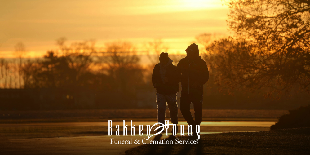 Two people walking side by side on a spring path, symbolizing support for someone who is grieving