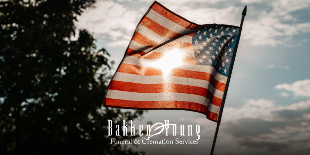 “Small American flag and flowers at a grave, symbolizing grief and Memorial Day remembrance”