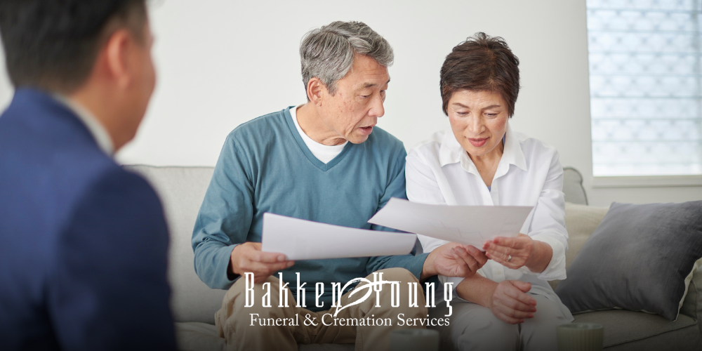 Funeral director sitting at a table with an older adult, reviewing simple planning documents together